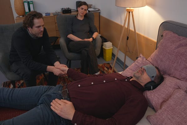 Mann liegt auf Bett. Therapie mit LSD.